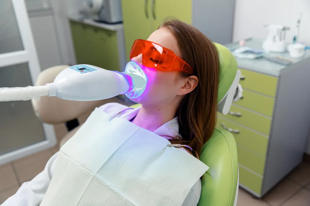 Patient receiving professional teeth whitening treatment at the dentist